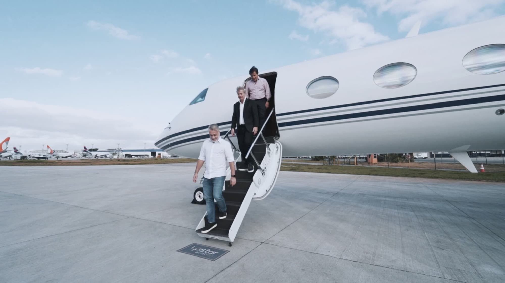 Desembarque do Gulfstream da UpStar Aviation no pátio, com o tapete da marca ao pé da escada